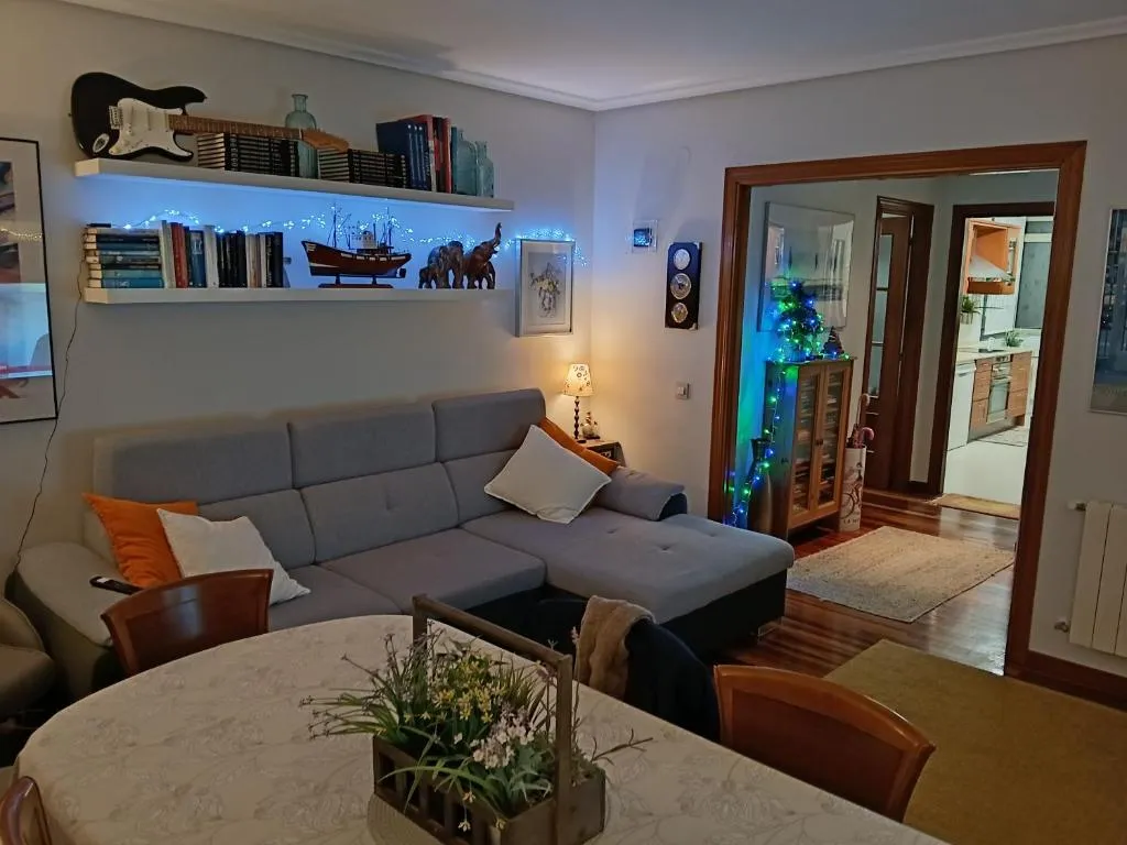 Zona de estar con sofá y biblioteca